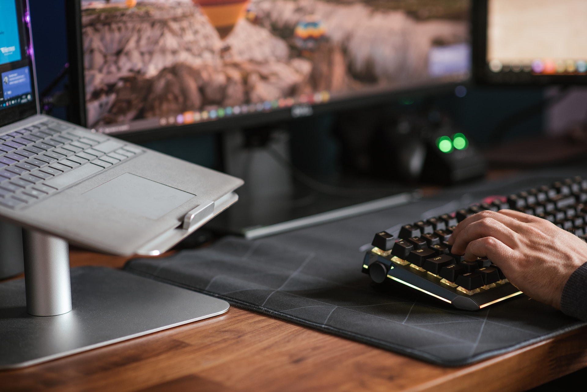 Close up shot of a man using a keyboard in front of a computer