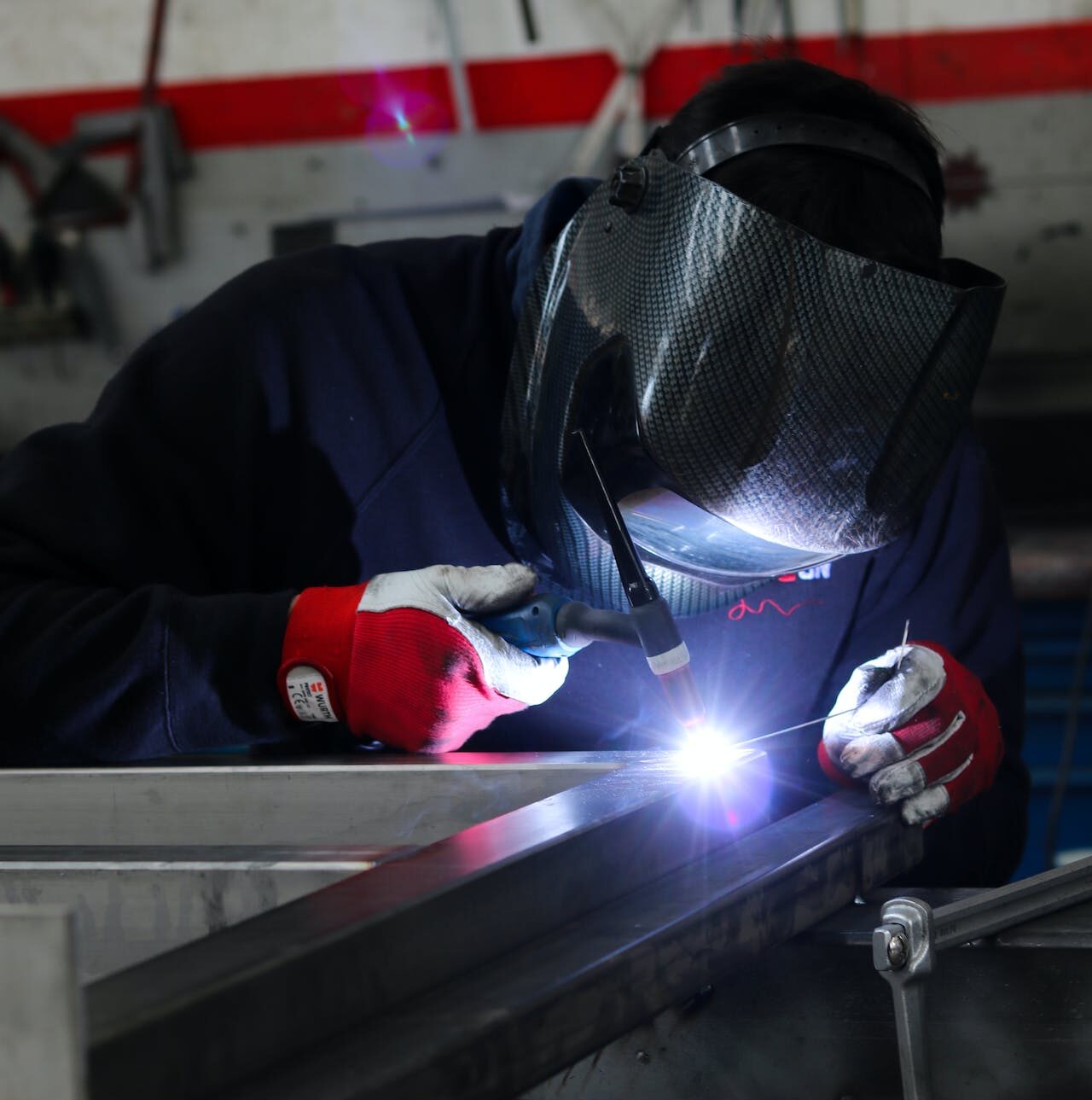 A man carry out his manufacturing job in his career as a welder