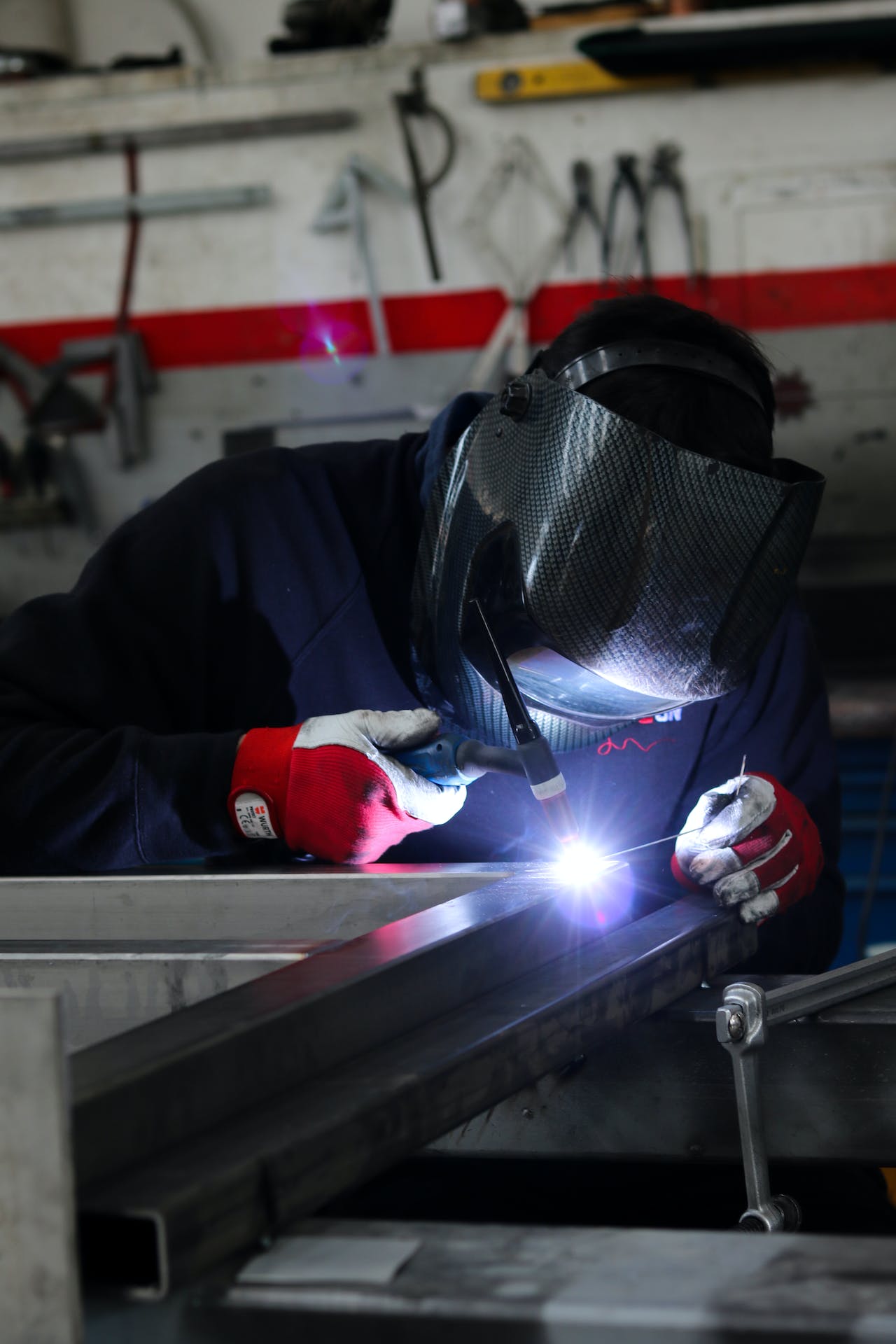 A man carry out his manufacturing job in his career as a welder